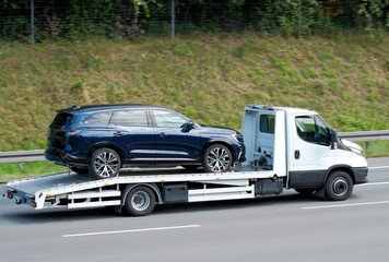 Road Assistance Tow-Truck With New Family SUV On Flatbed