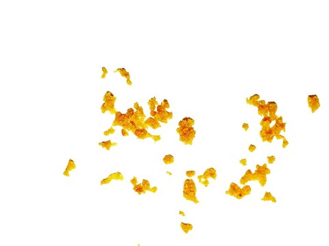 crispy fried flour crumbs flying on an isolated white background, for design, fried chicken. Fried popcorn chicken falling in the air isolated on white background.