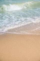 Closeup of waves sand beach and blue summer sea.