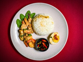 Stir-fried seafood with holy basil served over rice, a spicy and aromatic Thai street food dish packed with shrimp, squid, and fish.
