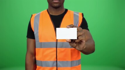 Construction worker in safety vest presenting blank business card mockup with green screen background for corporate branding and marketing
