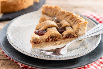 Slice of traditional Pastafrola pie with guava filling, also known as Cuban pae on rustic wooden table.