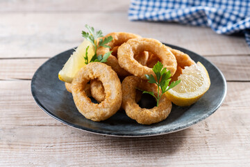 Crispy fried squid rings on wooden table