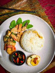 Stir-fried seafood with holy basil served over rice, a spicy and aromatic Thai street food dish packed with shrimp, squid, and fish.