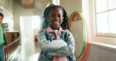 Child, portrait and happy in hallway for education, learning opportunity or back to school. Girl, arms crossed or smile at montessori for development, growth and knowledge or scholarship in Brazil