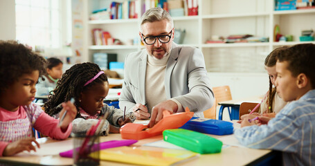 Education, learning or study with students and teacher at desk in classroom for child development....