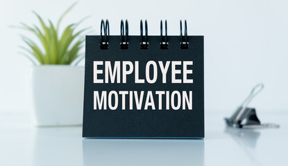 A black notebook with the words Employee Motivation written on it