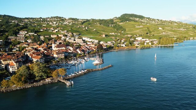 Aerial view of Lutry town, Switzerland, featuring the harbor with boats, contrasted by the blue water and the green landscape, Lutry, Vaud, Switzerland.