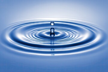 Water droplet impacting a smooth surface, creating concentric ripples