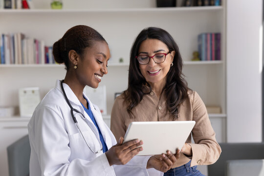 Doctor showing to older woman patient diagnostics result on tablet