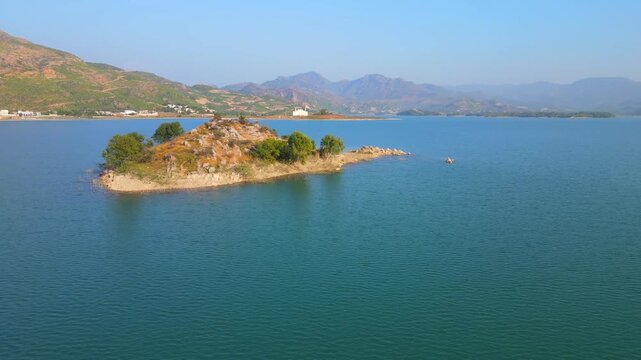 Aerial view of an island sitting in the middle of Khanpur Lake, with mountains in the backdrop, Khanpur, Khyber Pakhtunkhwa, Pakistan.