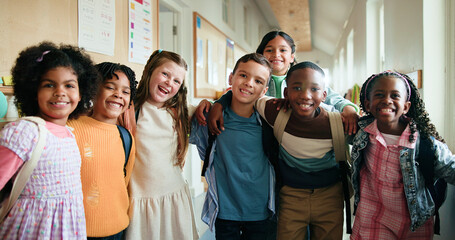 Portrait, group and happy children hug for education, teamwork or smile in elementary school. Friends, kids and students embrace for support with development, learning or laugh in hallway together