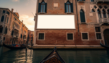 A large, blank white billboard is mounted on a classic brick building above a canal in Venice, Italy, offering a beautiful and unique mockup for advertising.