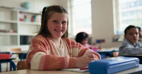 Happy, education and face of child in classroom at elementary school with confidence for learning. Smile, student and portrait of girl kid with pride for assessment at academic lesson at campus.