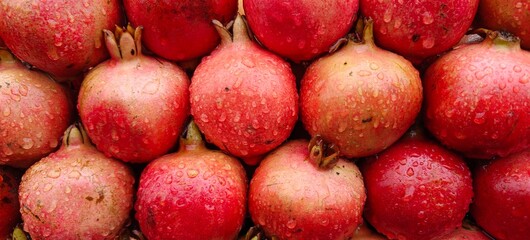 Close up shot of pile of fresh Raindrops on a pomegranate.