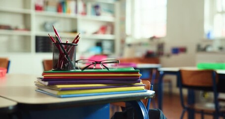 Glasses, books and stationary on table in classroom for education, learning and knowledge growth. Equipment, workbook and study material for lesson, grading homework and academic activity at school