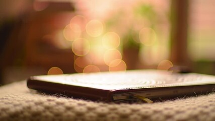 A closed notebook rests on a textured surface, with a blurred background.