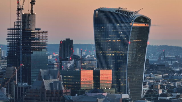 United Kingdom, London: Aerial view capturing the London skyline at sunset, highlighting the iconic Walkie-Talkie building amidst modern urban architecture. Drone flight