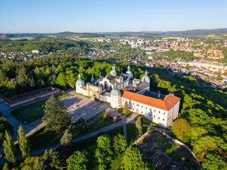 The Baroque complex of Holy Mountain in Pribram stands amidst lush greenery, serving as an important pilgrimage destination with historical and spiritual significance, attracting visitors year-round.