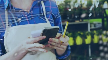 Animation of data processing over hands of caucasian female seller using payment terminal - Powered by Adobe