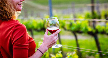 happy woman tasting wine in a vineyard