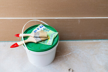 Bucket of paint with a brush on top. Top view.