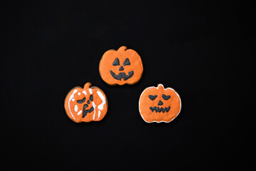 Halloween gingerbread cookies on a dark background. Bright homemade cookies for Halloween party. Halloween background with space for text. Top view. Mock up
