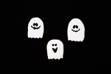 Halloween gingerbread cookies on a dark background. Bright homemade cookies for Halloween party. Halloween background with space for text. Top view. Mock up