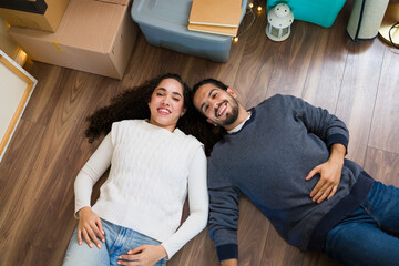 Top view of happy couple lying on floor of new home at christmas time