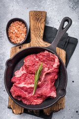 Ready for grilling Raw hanging tender or Hanger beef steak in a pan. grey background. top view