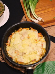 Double cheese pineapple pizza served in a hot pan, rich, cheesy, and delicious with a tropical twist.