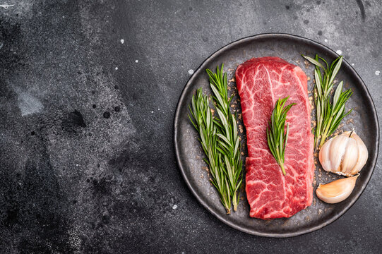 Australian Oyster Top blade steak, Fresh Beef shoulder meat on plate. black background. top view