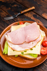 Prosciutto Cotto Ham and cheese sandwich, toast with sliced meat, cheese and salad. wooden background. top view