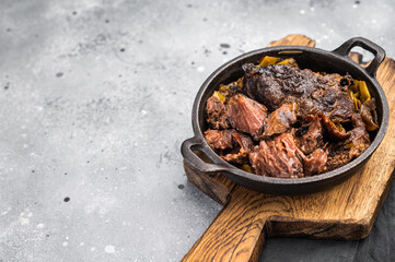 Red Wine Braised Beef Cheek meat with Creamy sauce in a skillet. grey background. top view