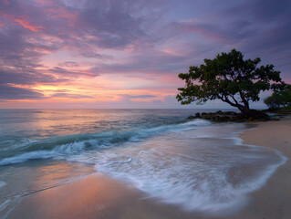 Tranquil Beach with Green Tree at Colorful Sunrise by Ocean Waves