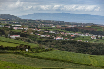 Obraz premium Green hills and traditional white houses in Azores islands Portugal