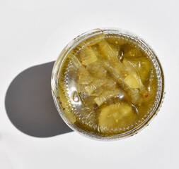 Jar of pickled cucumbers upside down isolated on white top view