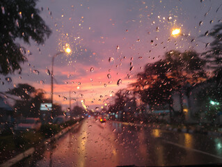 Raindrops on Glass with Pink Sunset Sky and Street Lights