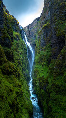 Obraz premium Discovering the hidden Glymur waterfall amidst lush green valleys of icelands unique landscape