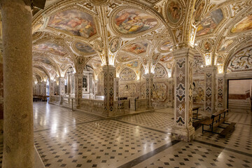 Salerno, Italy - 07 May 2025: View of the Saint Matthew crypt ornate columns reaching towards the frescoed ceilings, a symphony of light and shadow dancing on the marble floor.