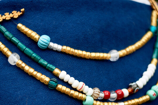 Beads in the old style against the background of blue linen fabric. Vikings, Slavs. Pastiche.
