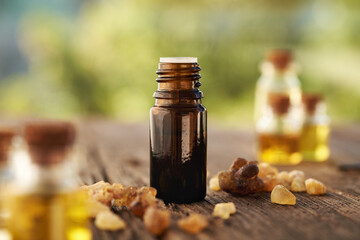 A bottle of frankincense essential oil with frankincense crystals