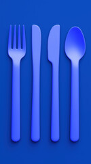 Blue plastic cutlery set of fork knife knife spoon neatly aligned on blue background with minimal mood