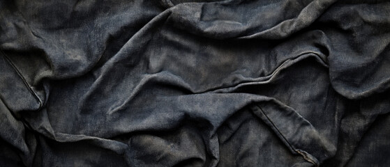 Fototapeta premium Dark fabric with textured folds, the play of light and shadow emphasizes the texture of the material. Suitable for design projects, fashion collections, and the textile industry.