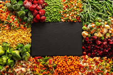 Vibrant seasonal vegetables and fruits frozen for winter storage, displayed on a dark ebonite board, highlighting the fresh, organic harvest ready for future meals and healthy eating