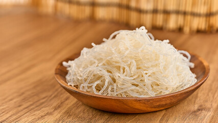 closeup Korean glass noodle vermicelli for Japchae food in wood bowl on wooden table food background with copy space