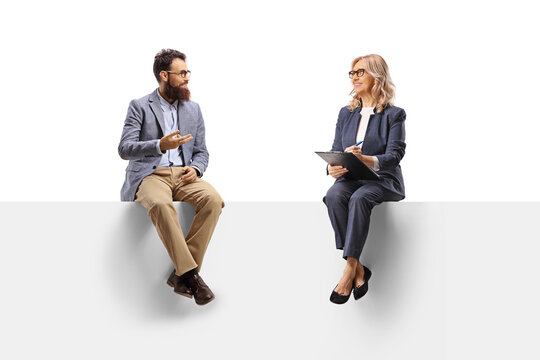 Man sitting on a panel and having a conversation with a professional woman