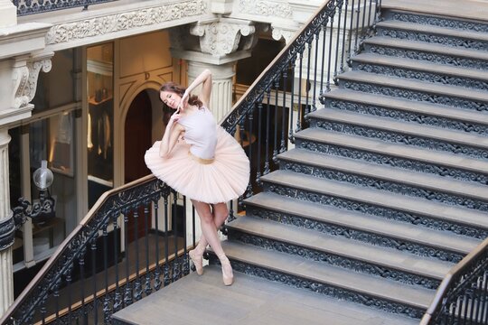 Ballet dancer in tutu jumping on historic staircase
