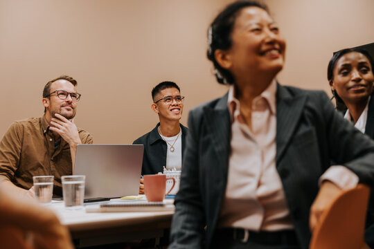 Male and female business coworkers listening to ideas shared in meeting at office board room
