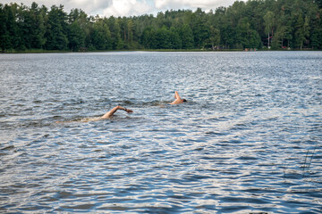 dwóch zawodników płynących podczas zawodów triathlonowych 